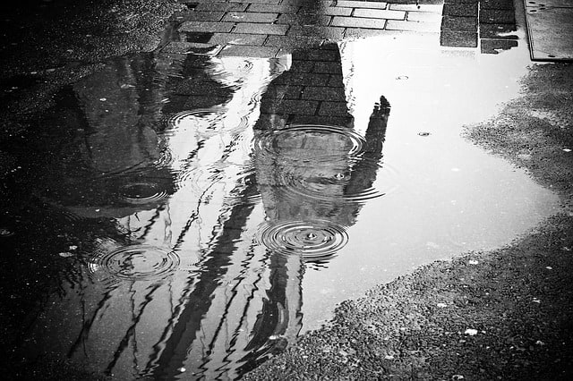 An image of the person's reflection in a puddle. Using reflection in photography is one of the well-known tips for street photographers.